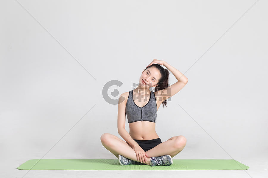 瑜伽垫上做运动动作的年轻女性图片素材免费下载