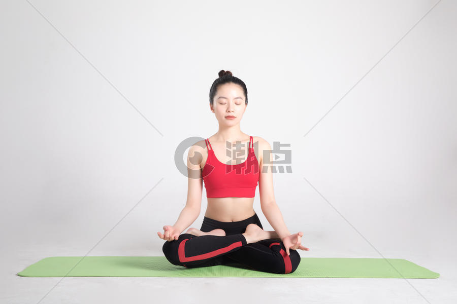 瑜伽垫上做瑜伽动作的年轻女性图片素材免费下载