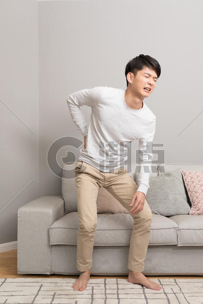 坐在沙发上腰疼的男性图片素材免费下载