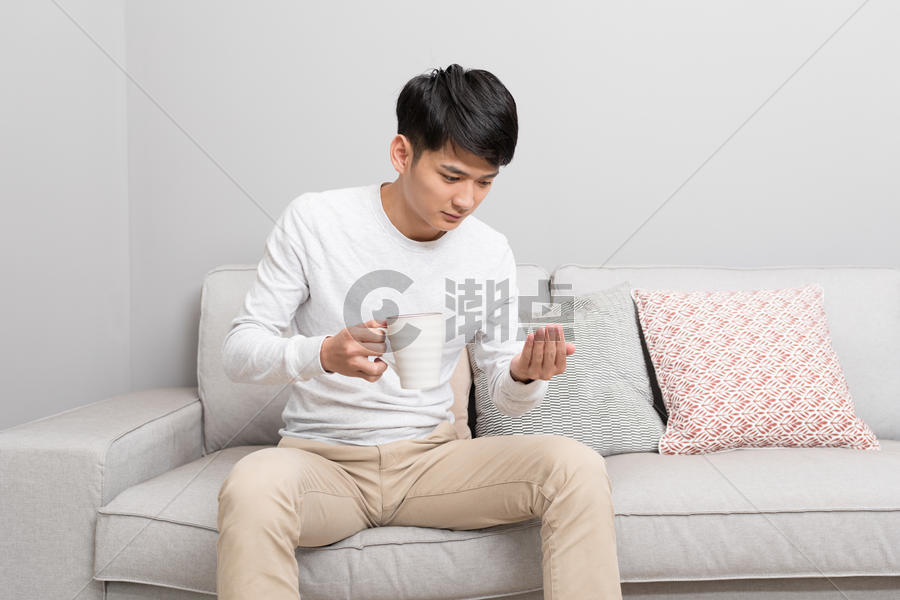坐在沙发上吃药的男性图片素材免费下载
