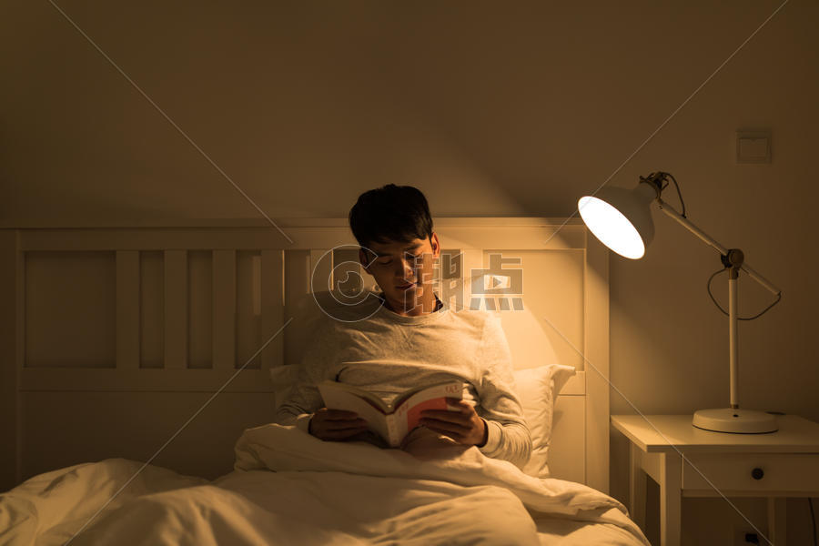 睡前坐在床上看书的男生图片素材免费下载