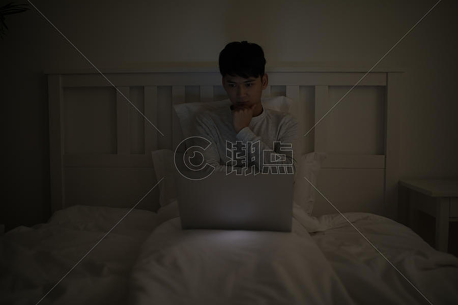 睡前坐在床上玩电脑打电脑的男子图片素材免费下载