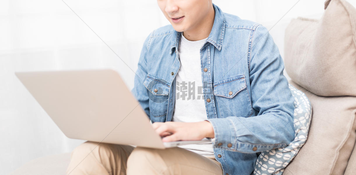 坐在沙发上打电脑的男子图片素材免费下载