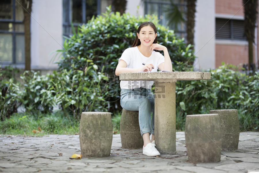 校园里坐在石凳上读书写字的女生图片素材免费下载