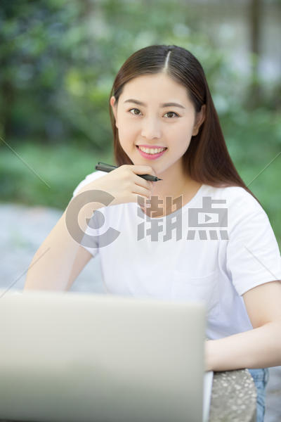 室外正在使用笔记本电脑的女性图片素材免费下载