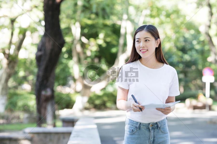 抱着书拿着笔的女同学图片素材免费下载