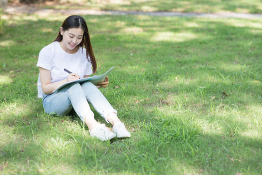 坐在校园草坪上看书学习的同学图片素材免费下载