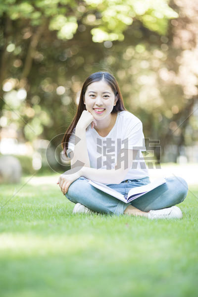 愉快地坐在草坪上学习的女同学图片素材免费下载