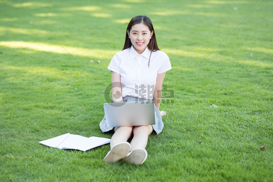 绿色草坪上休闲学习的女生图片素材免费下载