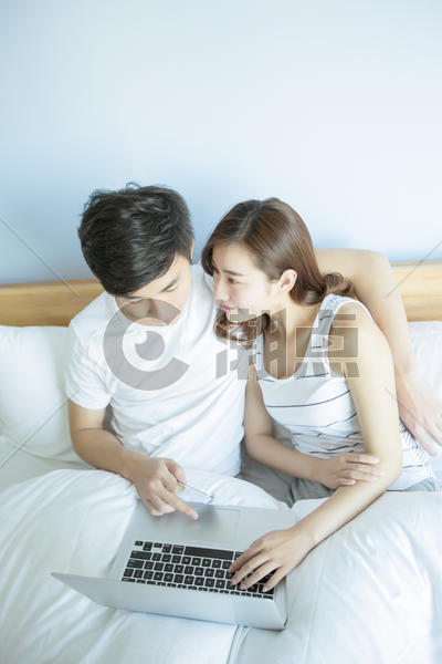 年轻情侣在床上玩电脑图片素材免费下载