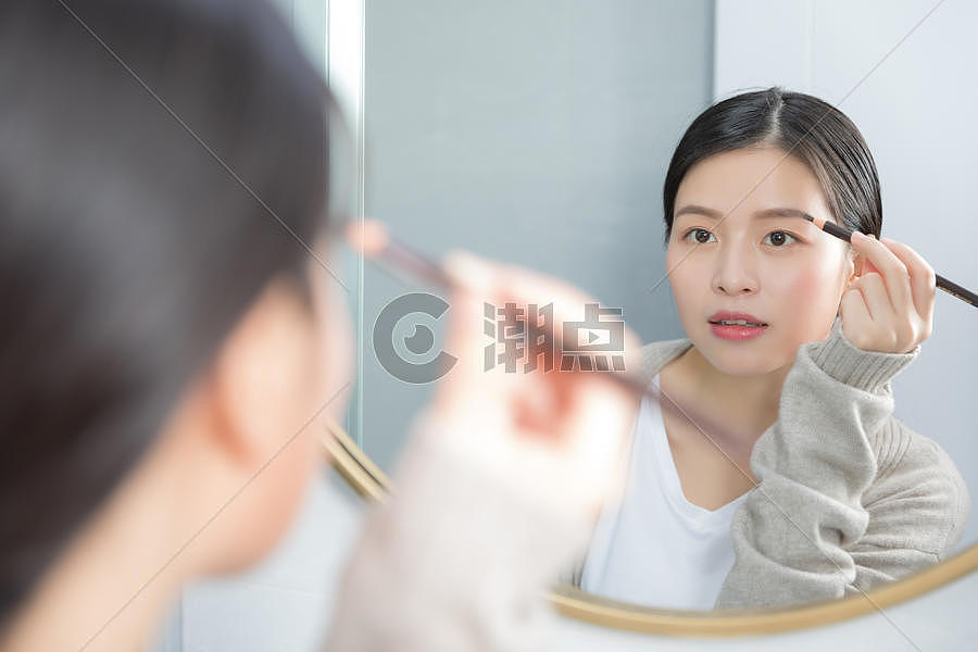 站在镜子前画眉的年轻女性图片素材免费下载