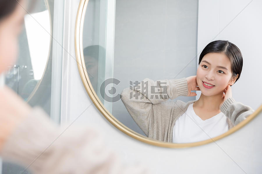 在家照镜子护肤美容的年轻女性图片素材免费下载