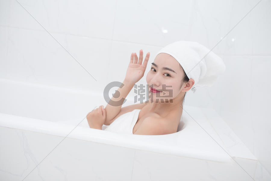 包着头巾躺在浴缸里泡澡的年轻美女图片素材免费下载