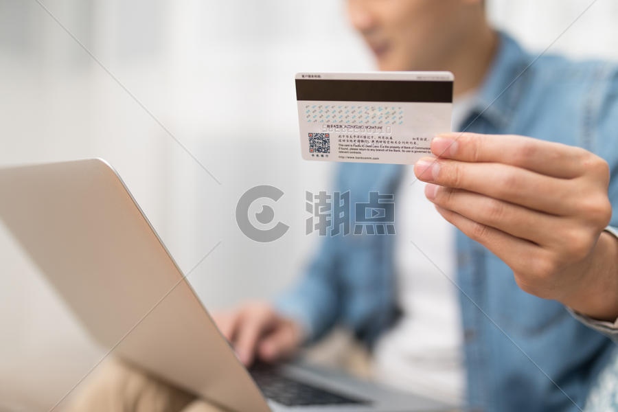 家居男子使用电脑手拿银行卡特写图片素材免费下载