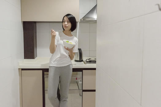 女子在厨房吃沙拉图片素材免费下载