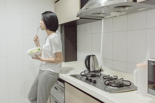女子在厨房吃沙拉图片素材免费下载