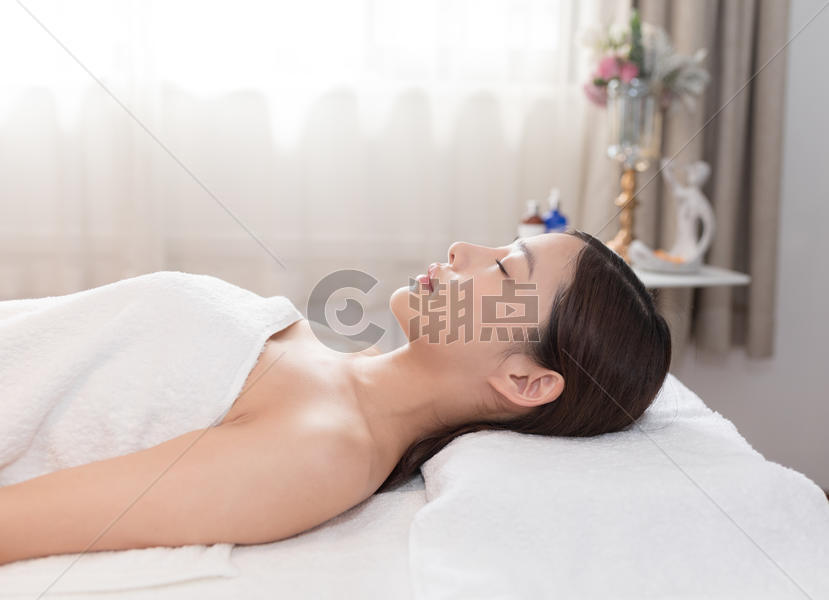 年轻美女躺着做美容SPA图片素材免费下载