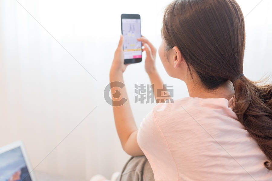 家居女性坐在沙发上玩手机图片素材免费下载