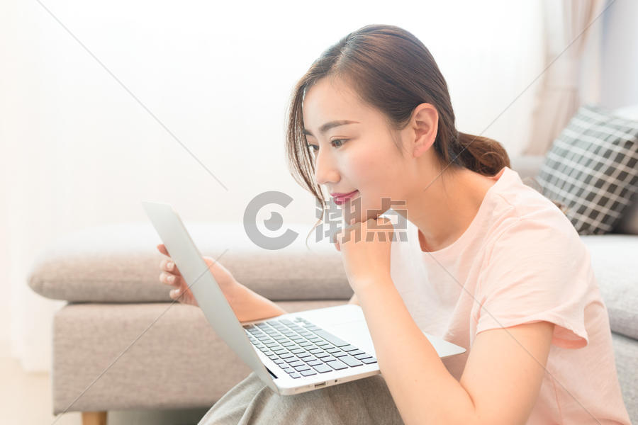 年轻美女靠着沙发玩电脑图片素材免费下载