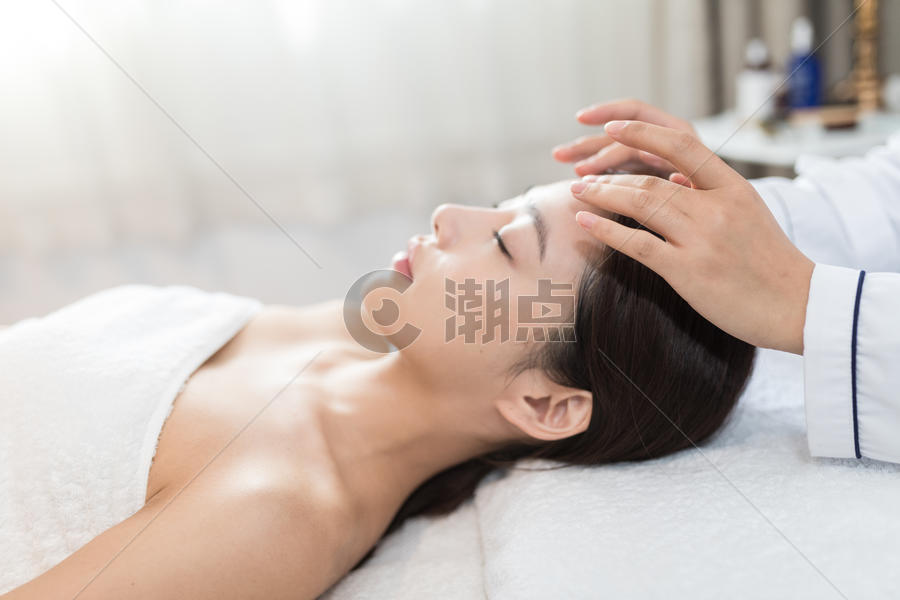 年轻美女躺着做SPA图片素材免费下载