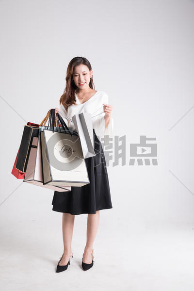 年轻女性提着购物袋看购物袋图片素材免费下载