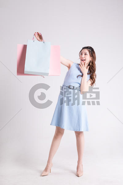 年轻女性提着购物袋看购物袋图片素材免费下载