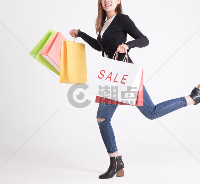 年轻女性提着购物袋走路图片素材免费下载