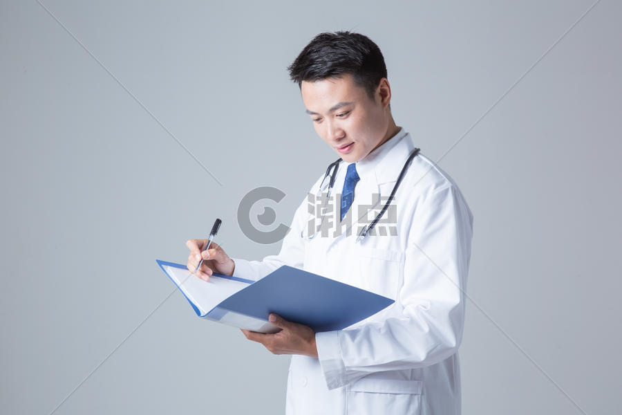 医生写医学报告棚拍图片素材免费下载