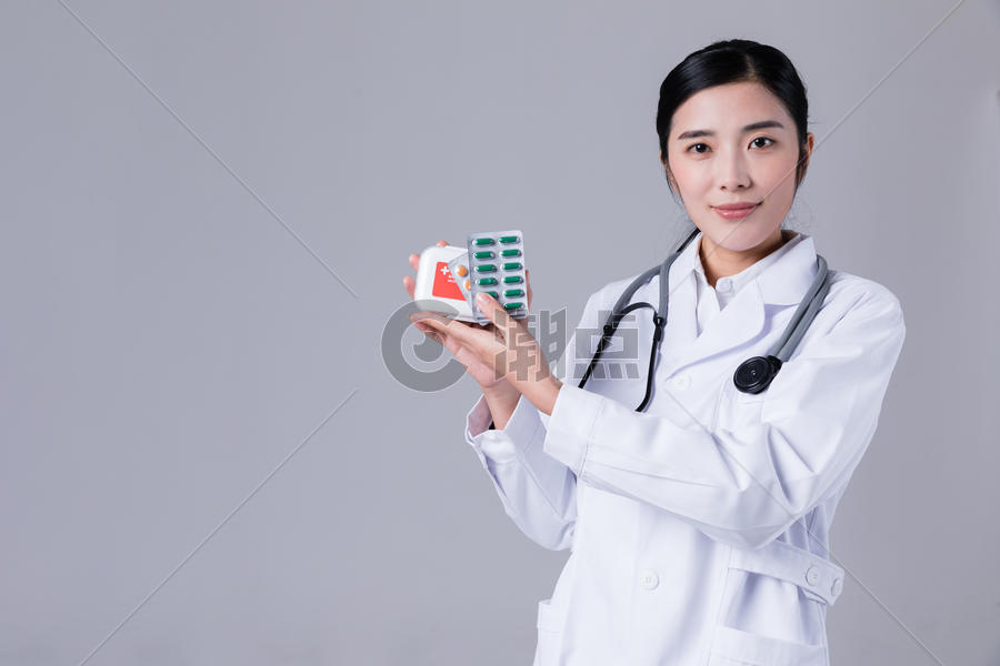 穿白大褂的女医生拿药观察图片素材免费下载