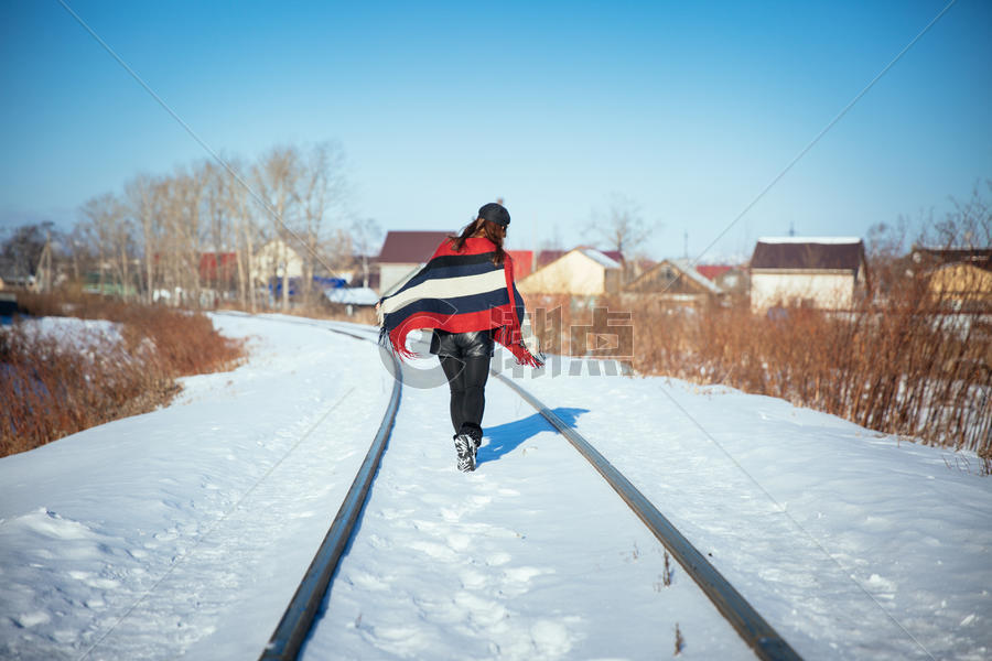在冬天雪地铁轨上行走的女孩图片素材免费下载