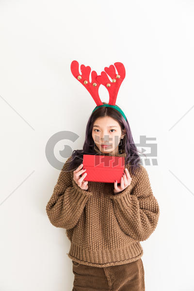 手拿礼盒带着鹿角的圣诞女性人像图片素材免费下载