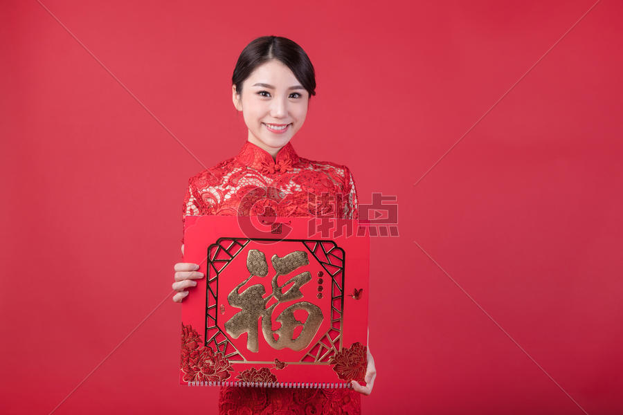春节穿旗袍的女孩手拿福字图片素材免费下载