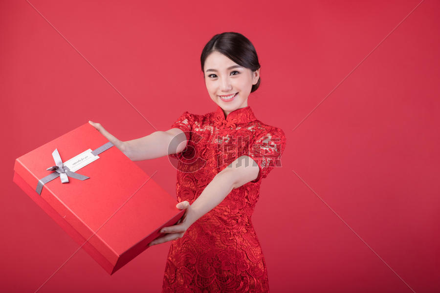 新年手递礼物的旗袍美女图片素材免费下载