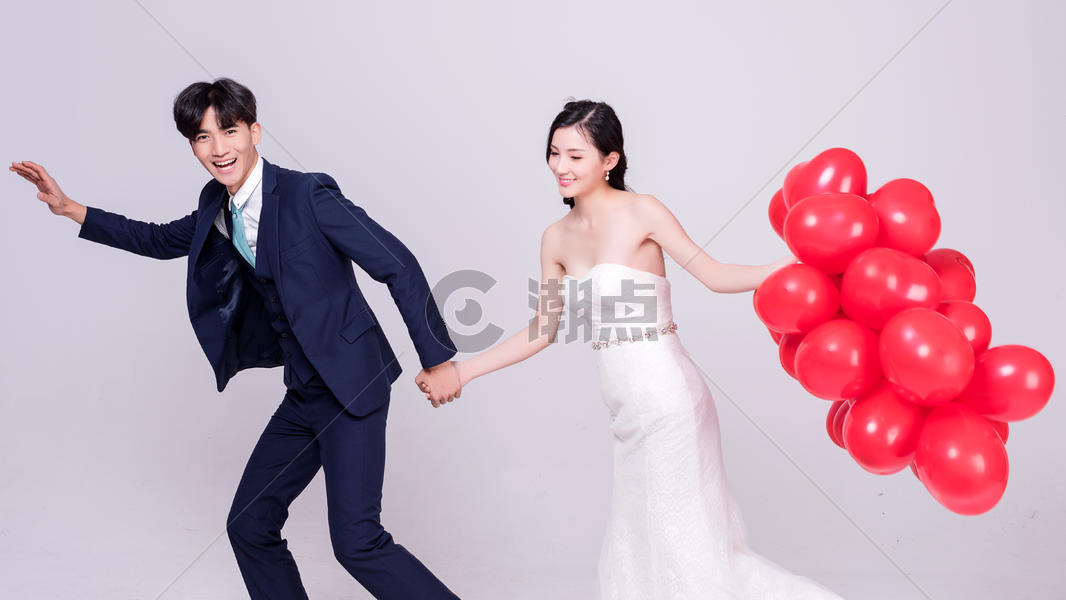 情侣婚纱手持红色爱心气球跳跃动作图片素材免费下载