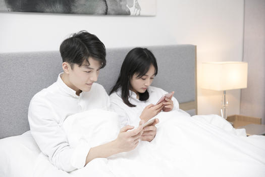 情侣在床上玩手机图片素材免费下载