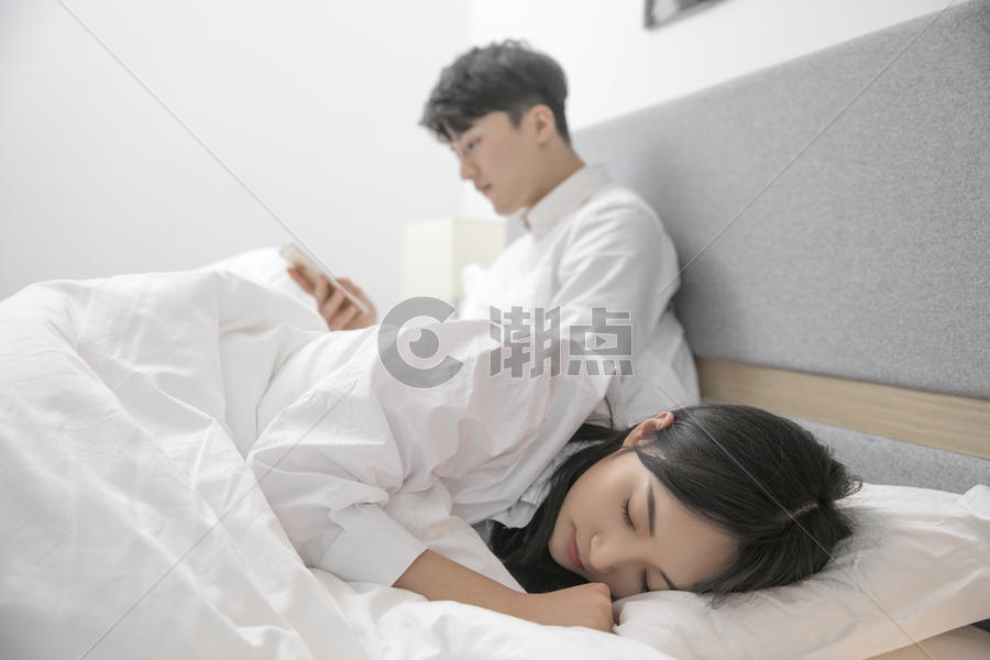 女生在睡觉男生在玩手机图片素材免费下载