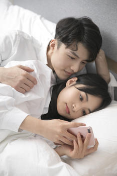 情侣在床上玩手机图片素材免费下载