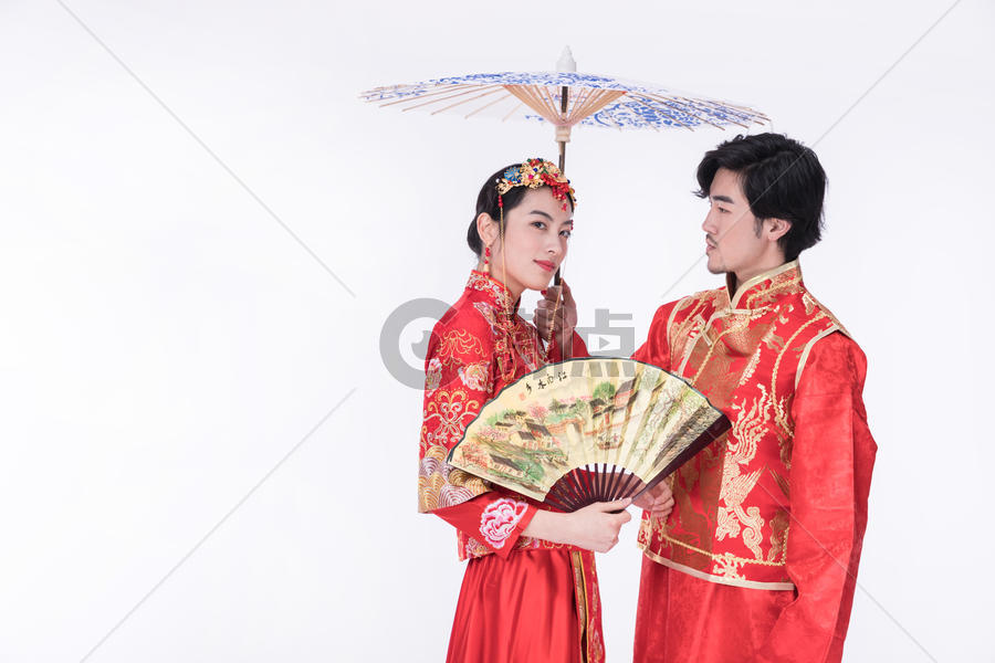 身着中式礼袍的年轻夫妻撑伞图片素材免费下载