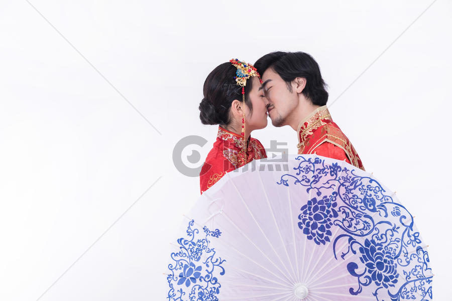 身着中式礼袍的年轻夫妻接吻图片素材免费下载