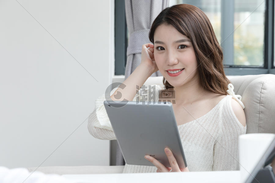年轻女性在卧室放松看平板电脑图片素材免费下载