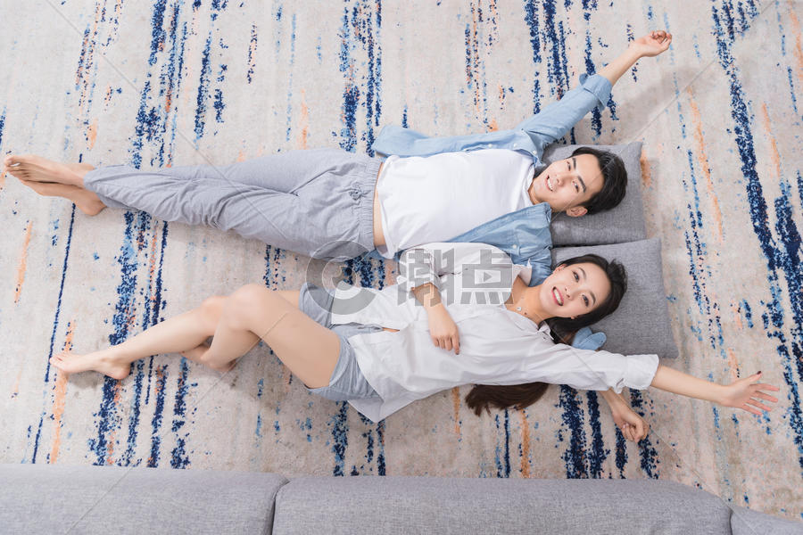 年轻情侣开心躺地毯上图片素材免费下载