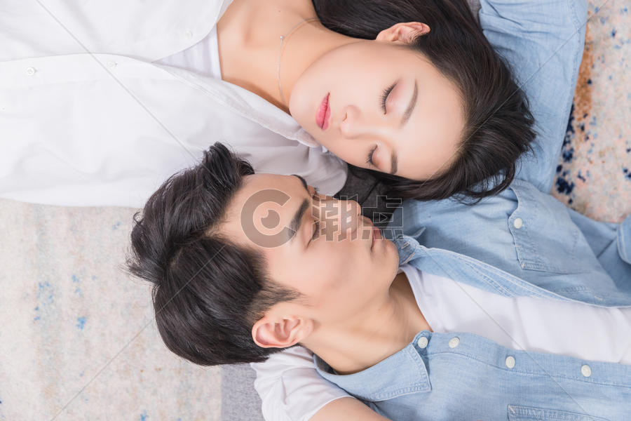 年轻情侣相依偎躺地毯上图片素材免费下载