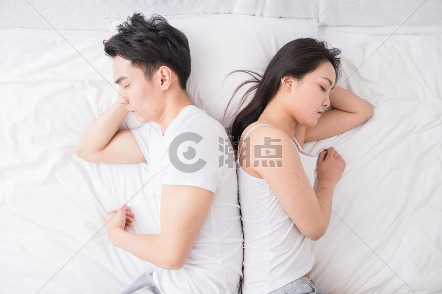 年轻夫妻背对背躺在床上图片素材免费下载
