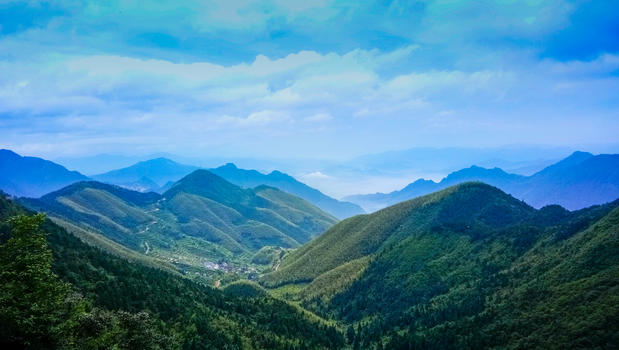 蓝天白云下起伏的山峦山脉图片素材免费下载