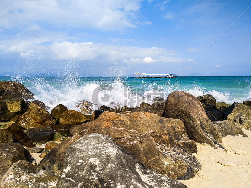 浪花拍打着海滩边的巨石图片素材免费下载