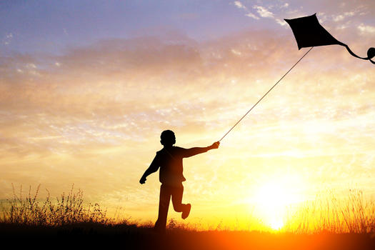 黄昏下放风筝的男孩图片素材免费下载