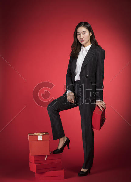 脚踩礼物盒的职业女性图片素材免费下载