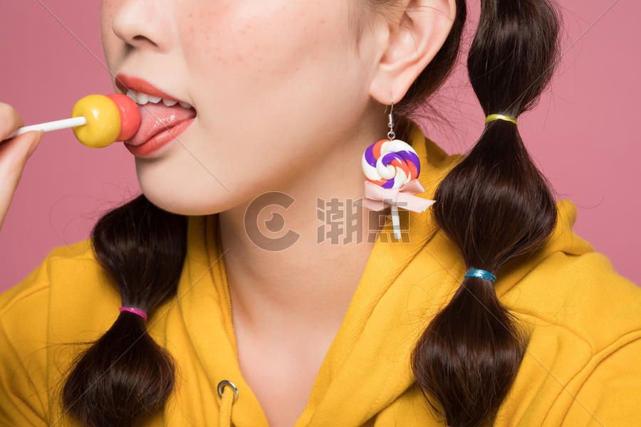 年轻双马尾女性吃棒棒糖图片素材免费下载