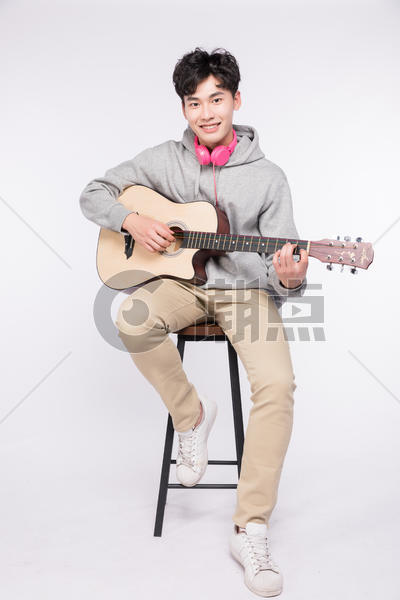 微笑着弹吉他的阳光男孩图片素材免费下载