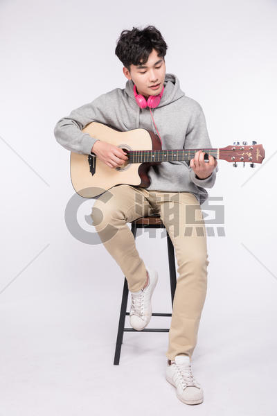 微笑着弹吉他的阳光男孩图片素材免费下载